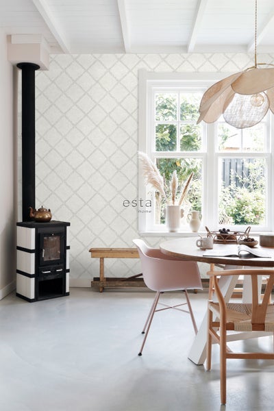 Heller Raum mit Kaminofen, Esstisch und geometrischer Tapete für ein helles und organisiertes Ambiente.