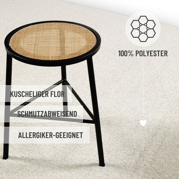 Weicher Hochflor-Teppich aus 100 Prozent Polyester, schmutzabweisend und für Allergiker geeignet, unter einem Hocker mit Rattansitz.