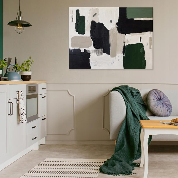 Wohnraum mit Sofa, Tisch, Küchenzeile und abstraktem Gemälde