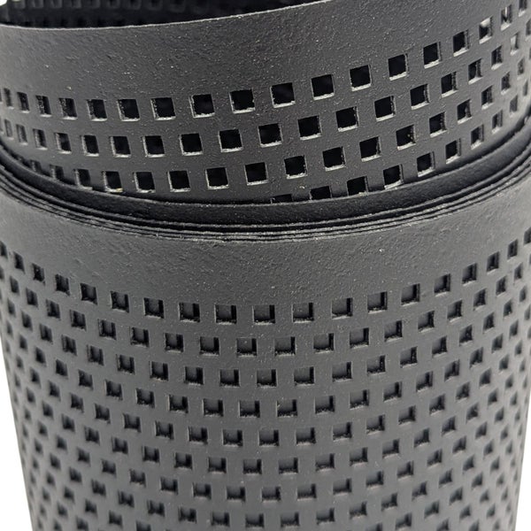 Nahaufnahme eines Drainagerohrs aus Kunststoff mit quadratischen Perforationen.