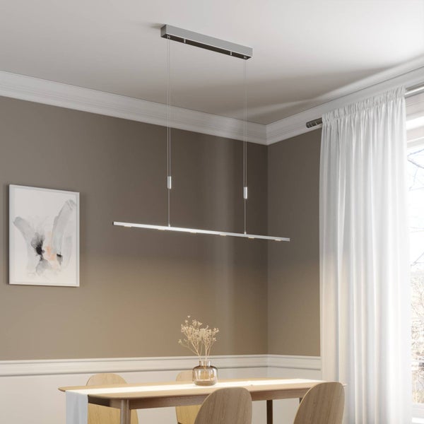 Lineare LED-Pendelleuchte aus Metall über einem Holztisch in einem hellen Esszimmer. Die minimalistische Hängelampe hängt an zwei dünnen Seilen.