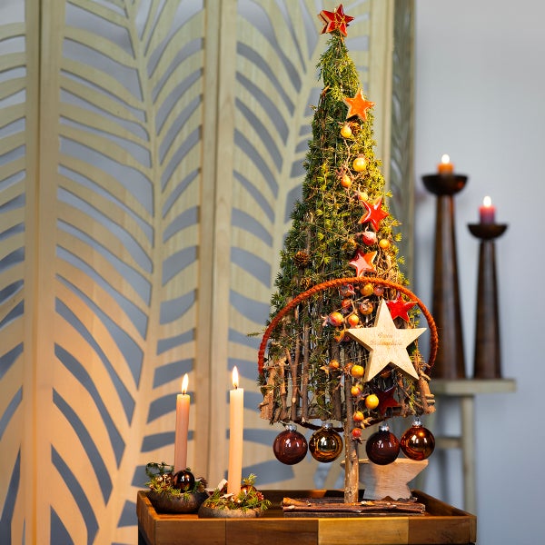 Dekorativer Weihnachtstischschmuck mit Baum, Kerzen und Ornamenten für festliche Stimmung