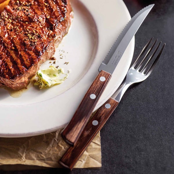 Ein Steak auf einem Teller mit einem Messer und einer Gabel