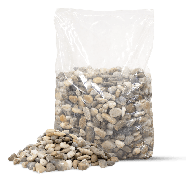 Zierkies in verschiedenen Farben in einem transparenten Beutel und ein kleiner Haufen Steine davor.