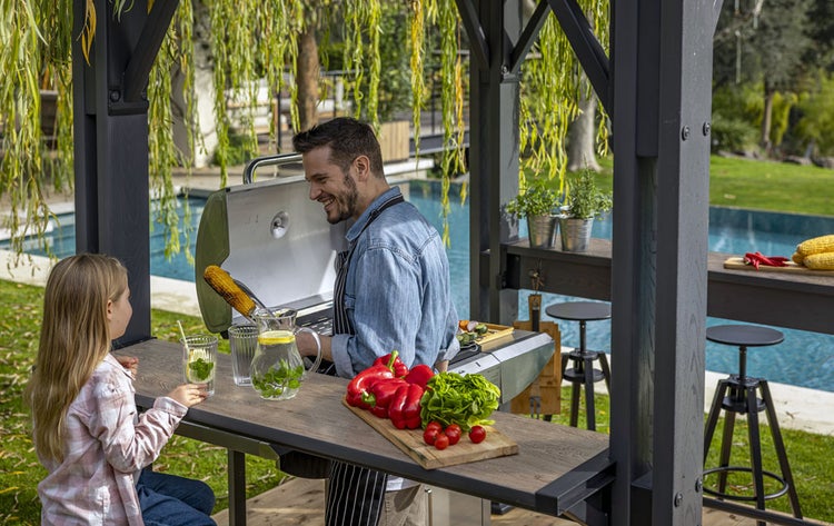 Szene im Gartenpavillon mit Grill, Vater und Tochter