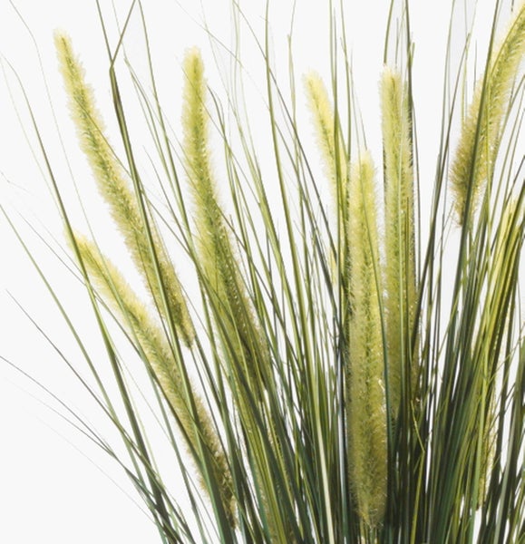 Detailaufnahme der langen grünen Blätter einer künstlichen Zimmerpflanze.