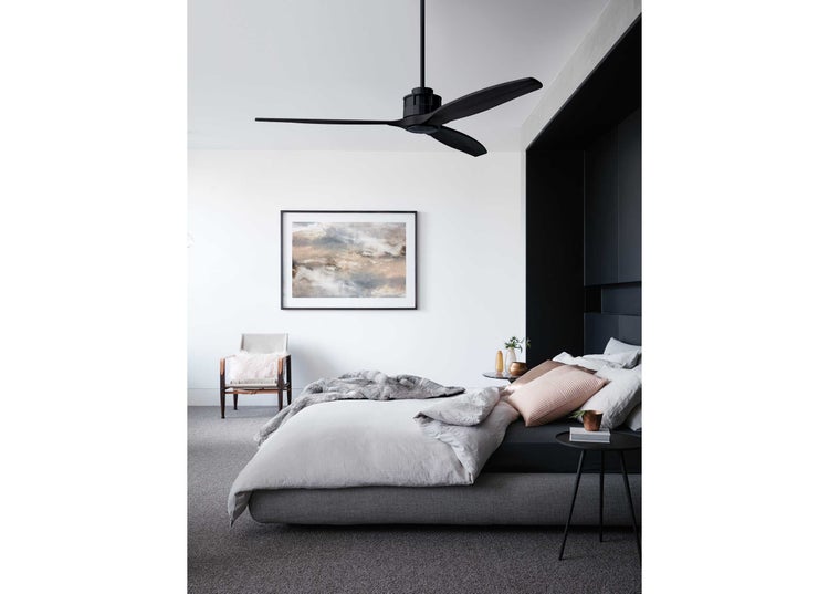 Moderner Deckenventilator in einem stilvoll eingerichteten Schlafzimmer mit Bett, Beistelltisch und Sessel.