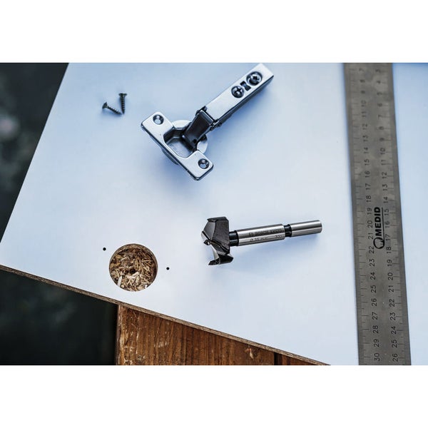 Forstnerbohrer, Scharnier, Schrauben und Messlineal auf Werkstück