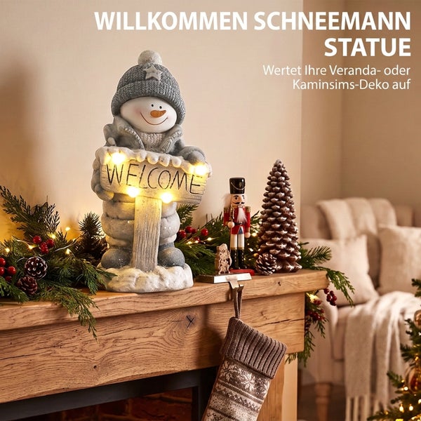Dekorative Schneemann Statue mit Willkommensschild und LED Beleuchtung als weihnachtliche Dekoration auf einem Kamin mit Nussknacker und Tannenbaum.