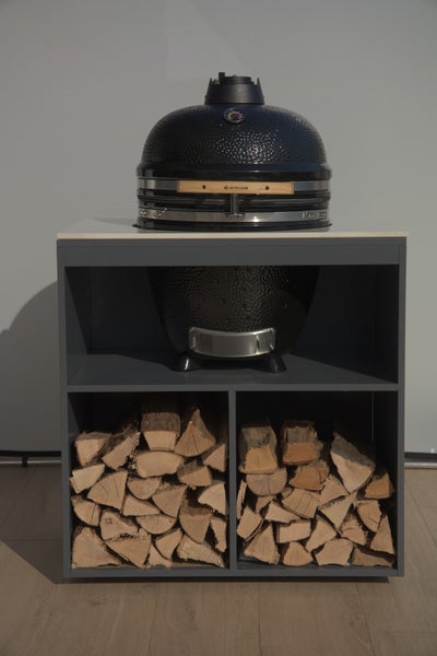 Keramikgrill auf Holzregal mit Brennholz