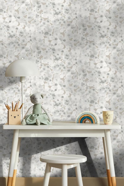 Helles Kinderzimmer mit weißem Schreibtisch, Hocker und gemusterter Tapete mit hellgrauen Aquarellkreisen. Enthält eine Tischlampe und Spielzeug.