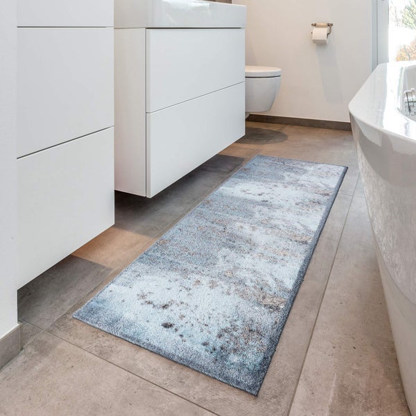 Badezimmer mit blauem Badteppich, Waschtisch und Badewanne