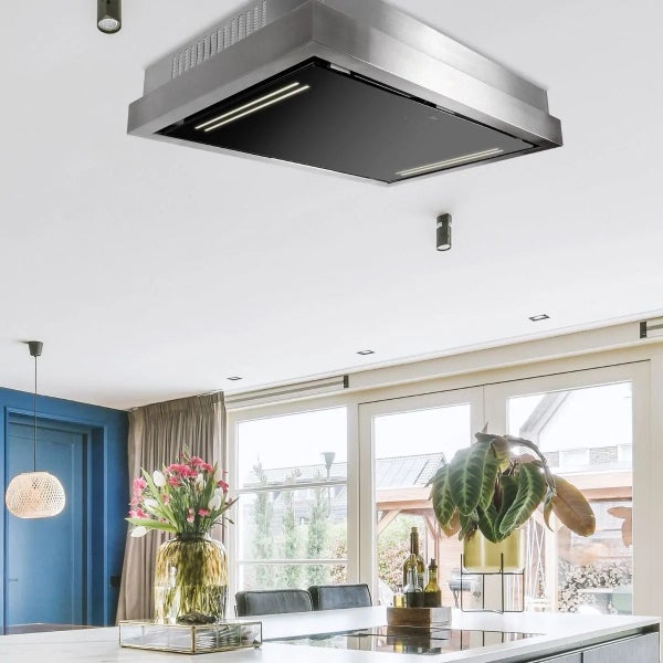 Moderne Deckenhaube aus Edelstahl mit LED Beleuchtung in einer hellen Küche mit Kochinsel.