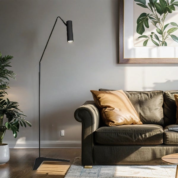 Wohnzimmer mit Stehlampe, Sofa und gerahmtem Pflanzenbild an der Wand