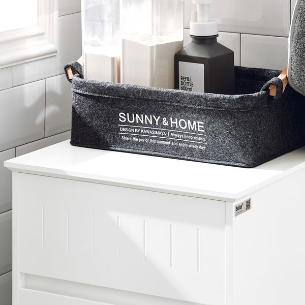 Aufbewahrungskorb aus Filz mit Griffen auf einem weißen Schrank