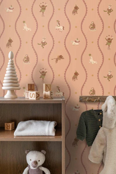 Vliestapete mit Zirkusmotiven wie Bären, Affen und Hunden im Kinderzimmer neben einem Holzregal mit Spielzeug.