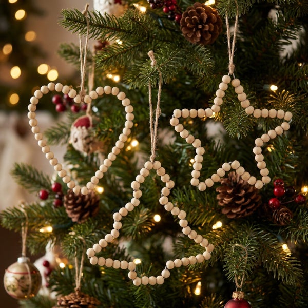 Drei hängende Weihnachtsanhänger aus Holzperlen in Herz Stern und Tannenbaumform am Weihnachtsbaum