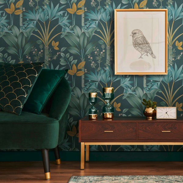 Wohnzimmer mit einem grünen Teppich, einer Stehlampe, einem Kamin und Zimmerpflanzen.