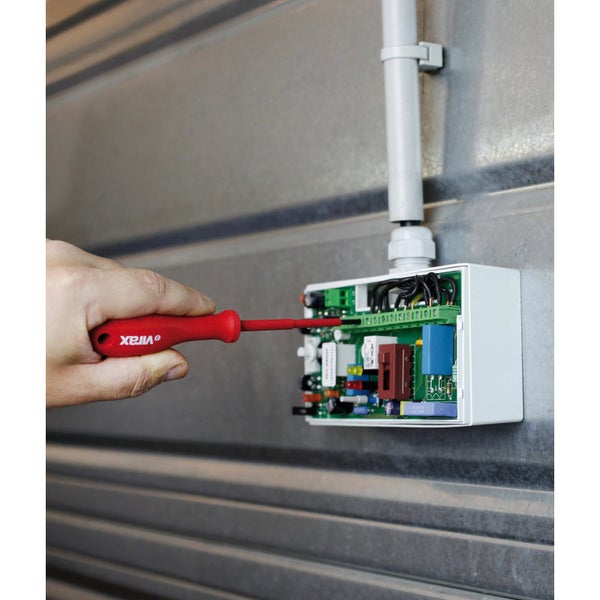 Person justiert elektronische Steuerung mit einem Schraubendreher