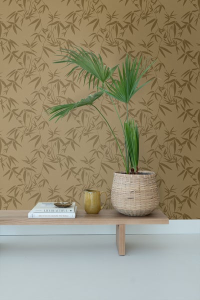 Raum mit Bambusmuster-Tapete, Holzregal, Topfpflanze und Dekorationsgegenständen.