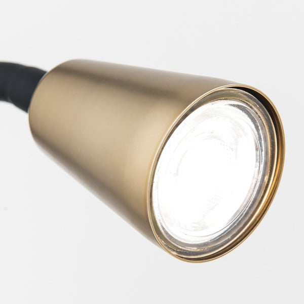 Nahaufnahme einer goldenen Leselampe.