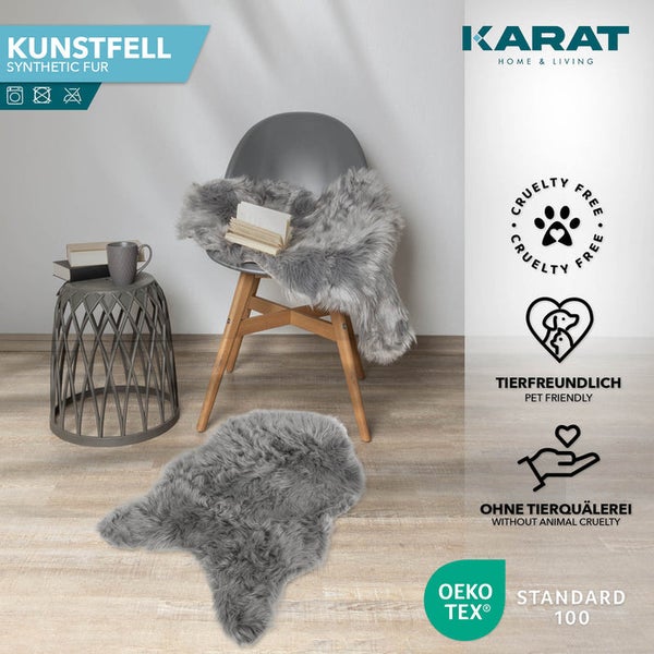 Graues Kunstfell auf Boden und Stuhl in modernem Raum. KARAT HOME and LIVING Logo, tierfreundlich, ohne Tierquälerei, OEKO-TEX Standard 100.