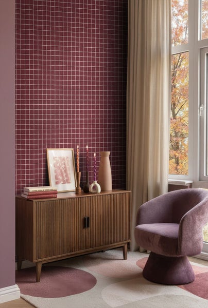 Wohnzimmer mit Mosaikfliesenwand, Holzkommode, Sessel und Teppich mit Kreismuster für ein gemütliches Ambiente