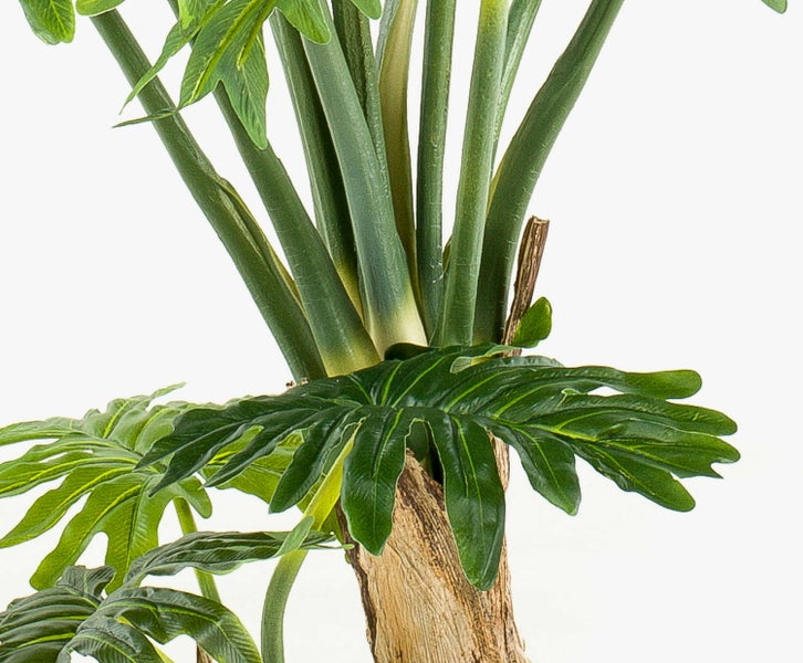 Künstliche Bambuspflanze mit grünen Blättern und braunen Halmen.