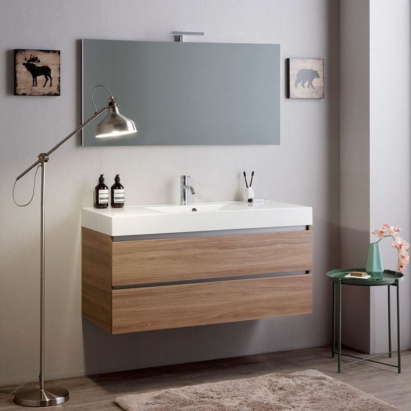 Modernes Badezimmer mit Waschtisch in Holzoptik, wandhängendem Unterschrank mit zwei Schubladen, großem Wandspiegel und Metallstehleuchte.