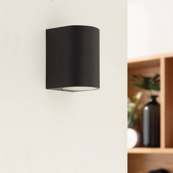 Hund liegt auf einem grauen Hundesofa mit Holzbeinen