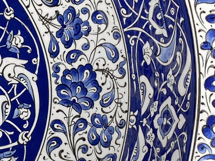 Detailaufnahme einer Keramikfliese mit blauem Blumenmuster