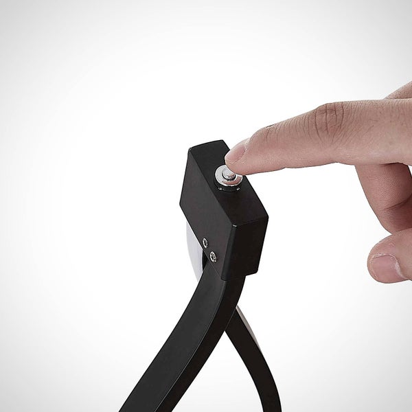 Nahaufnahme eines Fingers beim Drücken eines runden Knopfes an einem schwarzen Gerät.