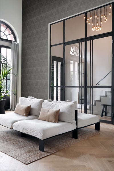 Heller Wohnraum mit Sofa, Teppich und Glastür