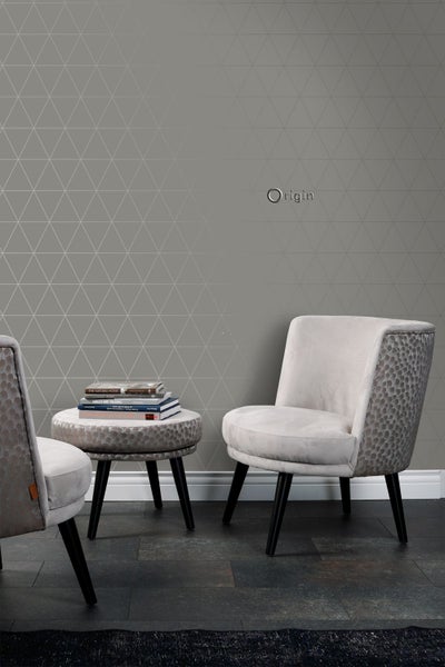 Wohnraum mit geometrischer Tapete, Beistelltisch und zwei Sesseln.