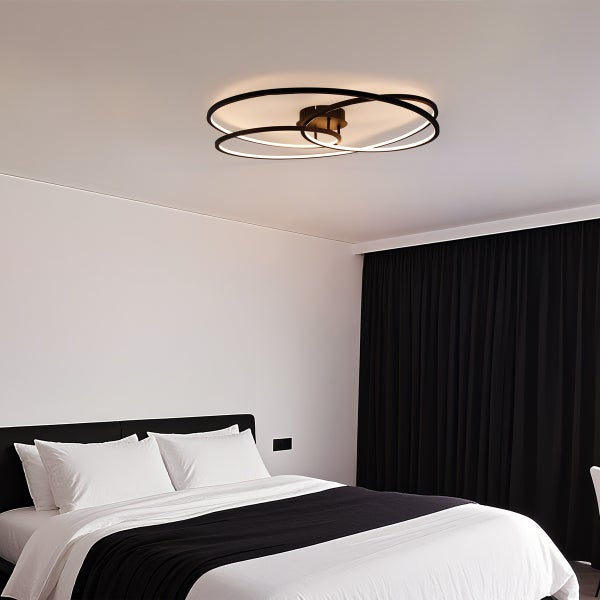 Deckenleuchte mit verschlungenen Ringen in einem Schlafzimmer