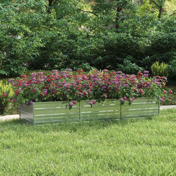 Rechteckiges Hochbeet aus verzinktem Stahl auf einer Rasenfläche, bepflanzt mit bunten Blumen vor einer grünen Hecke im Garten.