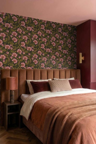 Schlafzimmer mit floraler Mustertapete im Paisley Stil, gepolstertem Kopfteil und gemütlicher Bettwäsche.