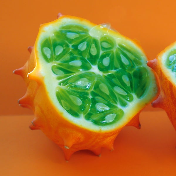 Halbierte Kiwano mit stacheliger Schale und geleeartigem Fruchtfleisch mit Kernen.