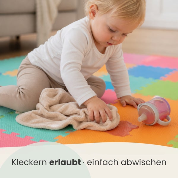 Kleinkind wischt verschüttete Flüssigkeit mit einem Tuch von einer abwischbaren Spielmatte aus Schaumstoff für Kinder.