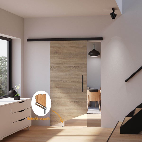 Moderne Schiebetür in Holzoptik mit schwarzer Laufschiene und Bodenführungsstift in einem hellen Raum.