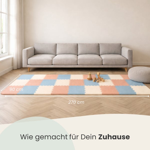 Eine Spielmatte aus Puzzleteilen, 270 mal 90 Zentimeter groß, in einem hellen Wohnzimmer mit grauem Sofa und Holzfußboden.