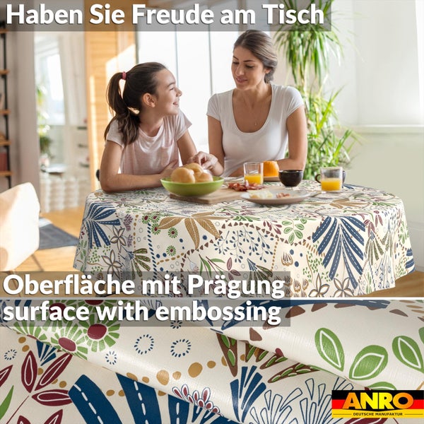 Runde Tischdecke mit Blumenmuster und geprägter Oberfläche auf einem Tisch in hellem Raum. Detailansicht. ANRO Deutsche Manufaktur Logo.