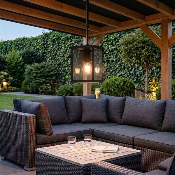 Moderne Gartenlounge unter einer Holzpergola mit Polyrattan-Ecksofa, Holztisch und einer schwarzen Außen-Hängeleuchte im Laternen-Stil.
