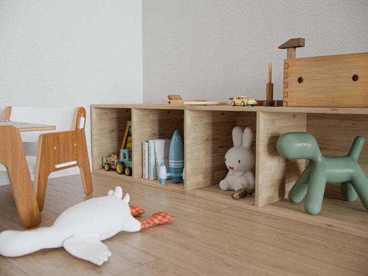 Organisiertes, helles Kinderzimmer mit offenem Holzregal, Spielzeugen wie Rakete und Hund sowie einem weißen Stofftier auf dem Boden.