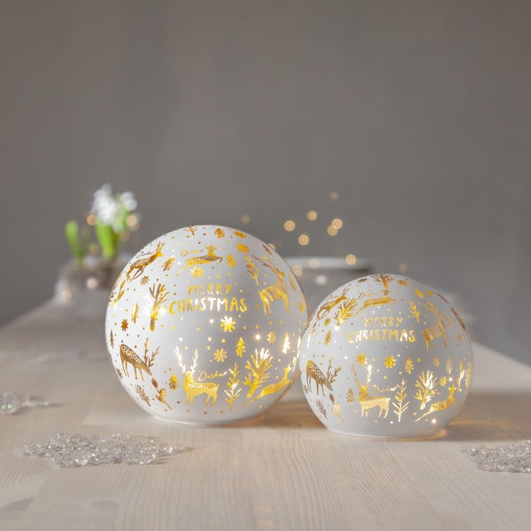 Dekorative Weihnachtsszene mit Bärenfiguren und beleuchtetem Haus.