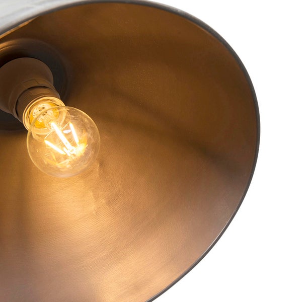 Nahaufnahme der Innenseite eines Lampenschirms mit Metalloberfläche und einem leuchtenden LED-Leuchtfaden-Leuchtmittel.