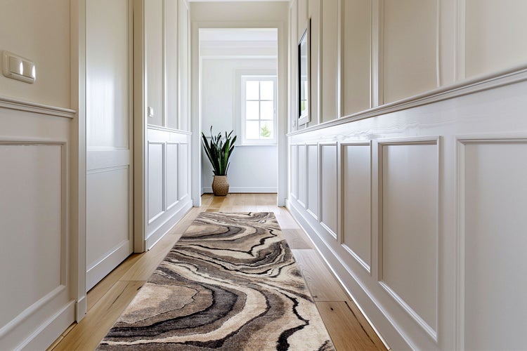 Ein heller Flur mit Wandverkleidung und Holzboden, auf dem ein moderner Läufer mit geschwungenem Muster liegt.