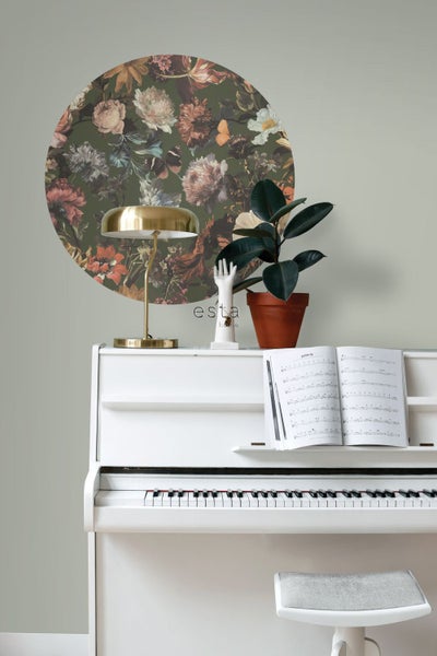 Szene mit einem weißen Klavier, einer Zimmerpflanze im Topf, einer goldenen Lampe und einem runden Wandtattoo mit Blumenmuster.