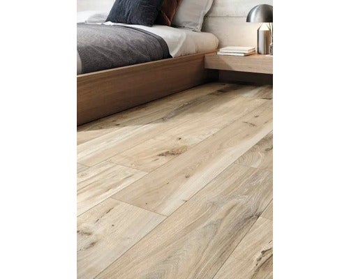 Heller Holzfußboden in einem Schlafzimmer mit Bett und Nachttisch.