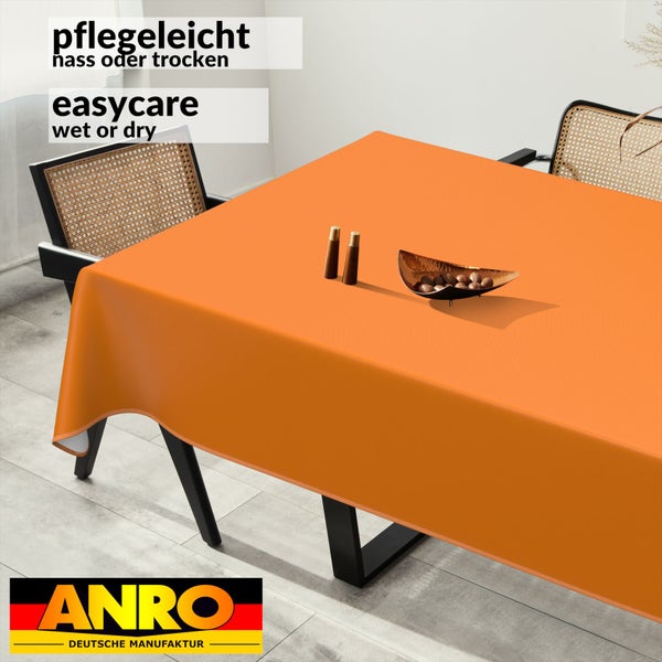 Orangefarbene Tischdecke auf einem Tisch mit Dekoration